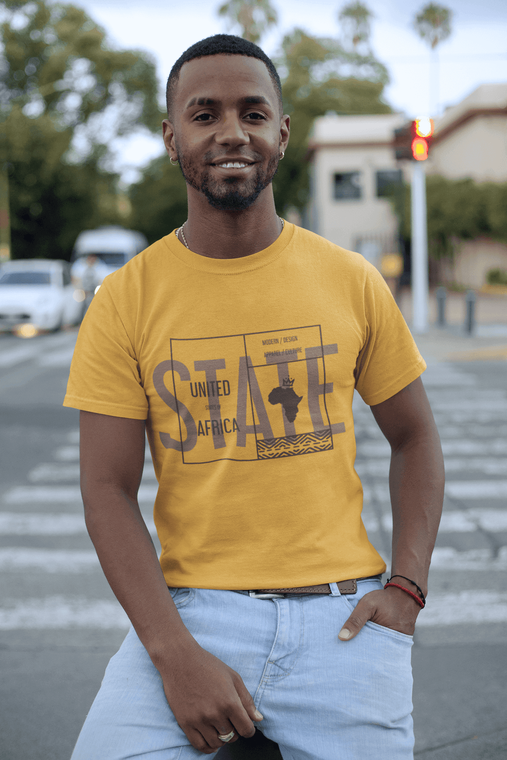 Man wearing an African State T-shirt featuring African-inspired graphics in a vibrant yellow color.