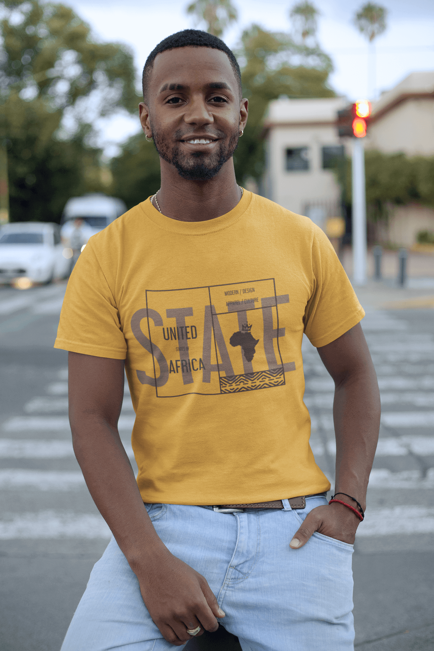 Man wearing an African State T-shirt featuring African-inspired graphics in a vibrant yellow color.
