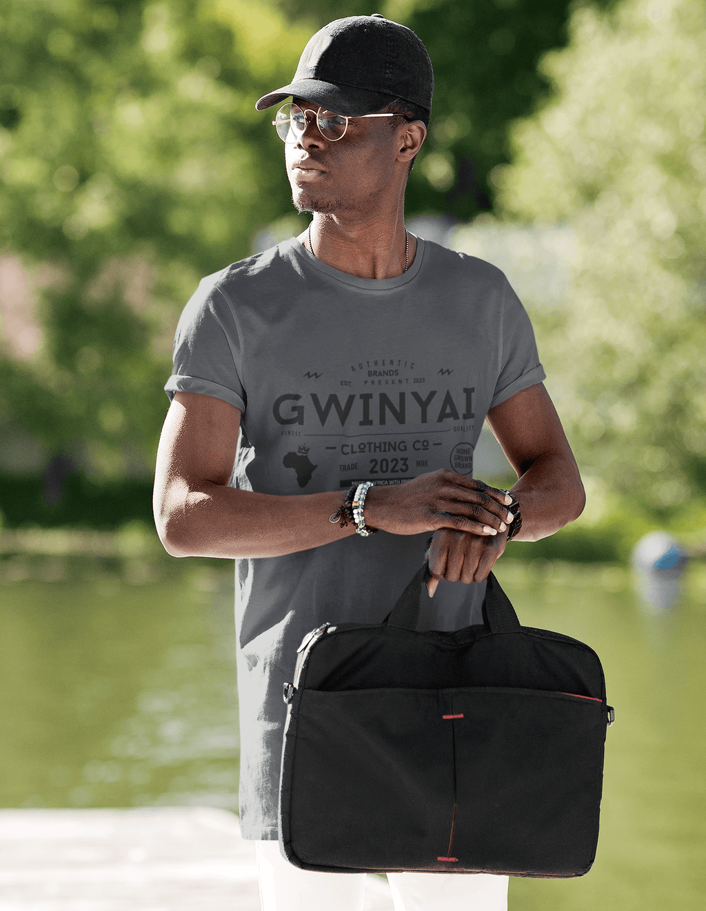Model wearing Gwinyai T-shirts by the water, showcasing comfort and style with a bold African design.