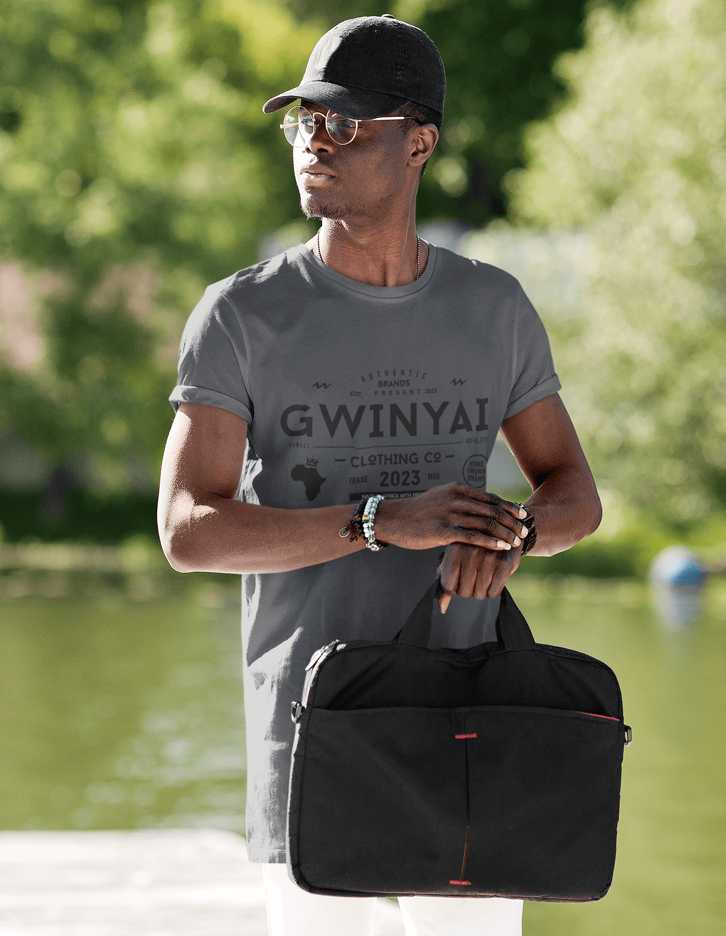Model wearing Gwinyai T-shirts by the water, showcasing comfort and style with a bold African design.